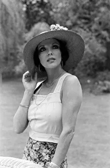 Actress Joan Collins modelling outfits that she will wear on a trip to Tokyo to judge a