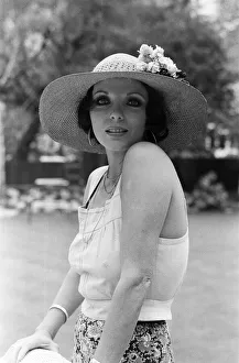 Actress Joan Collins modelling outfits that she will wear on a trip to Tokyo to judge a