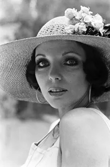 Actress Joan Collins modelling outfits that she will wear on a trip to Tokyo to judge a