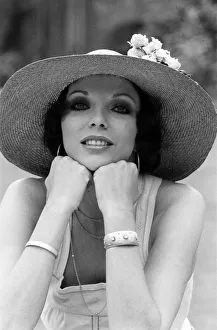 Actress Joan Collins modelling outfits that she will wear on a trip to Tokyo to judge a