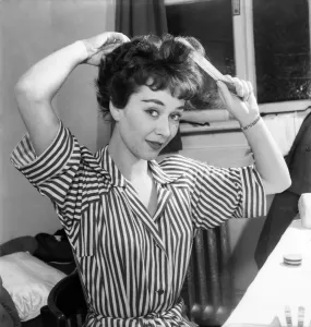 Actress Joan Griffiths fixing her hair in her dressing room before going on stage