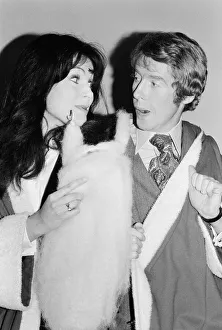 Actress Madeline Smith poses with Michael Crawford dressed in Father Christmas attire