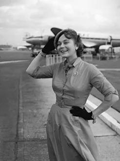 Aeroplane Prints: Actress Marta Torren holds on to her hat at the airport September 1956