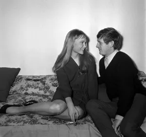Actress Mia Farrow with singer John Leyton April 1964 sitting on sofa talking