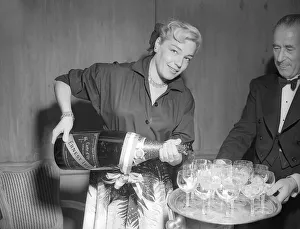 Necklace Prints: Actress Simone Signoret pouring glasses of champagne at a press conference