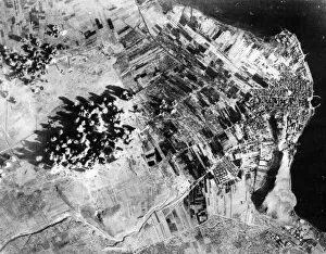 Explosions Prints: Administration buildings, hangers and revetments are covered by bomb bursts during a