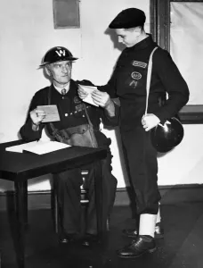 An Air Raid Precaution (ARP) warden and a messenger who wears the 1941 dark blue uniform