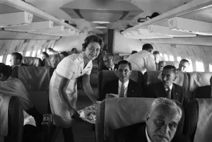 Serving Prints: An air stewardess serving food to passengers on board a Qantas Boeing 707 plane at London