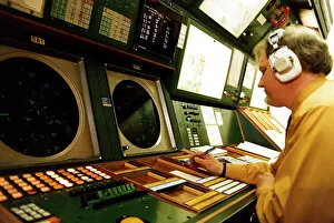 00187 Prints: Air Traffic control man wearing earphones headphones at instruments desk airport control