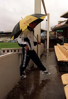 Alec Stewart England Cricket Captain June 1998 walks under an umbrella