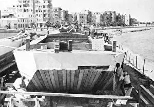 01454 Prints: Alexandria, Egypt. Canvas being nailed onto the sides of a flat bottomed barge called a