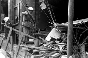 Alfieri. Air raid damage at Malden, London. Two civil volunteers search through