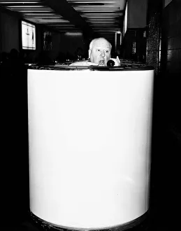 Alfred Hitchcock film director in a telephone booth in Heathrow Airport brochure