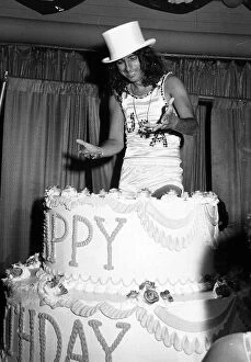 Images Dated 22nd June 1975: Alice Cooper American rock singer jumps out of a birthday cake 1975