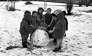 00098 Prints: All eyes on teacher as she puts the finishing touches to asnowman at Binley Nursery Schoo