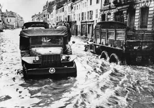 Flooding Prints: Allied traffic negotiates heavy rain in Rambervillers after a river in this french town