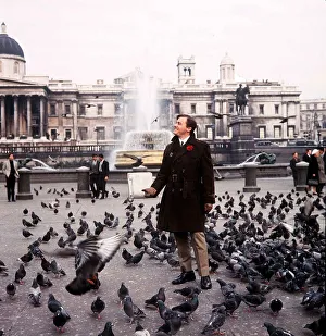 American actor Robert Vaughn feeds the pigeons in Trafalgar Square