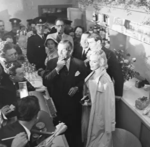 American actress Marilyn Monroe and Sir Laurence Olivier seek refuge from the waiting
