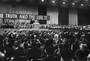 American evangelist Billy Graham addressing a huge crowd of people at Kelvin Hall in