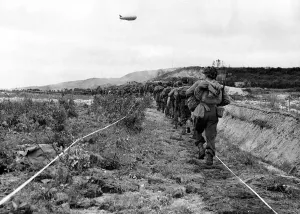 Infantry Prints: American infantrymen move along a taped path through a German minefield after their beach