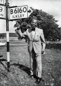 Sign Prints: American jazz musician Louis Armstrong by a signpost in Yorskhire