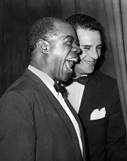 American jazz musician Louis Armstrong smiles as he receives cheers from his Glasgow fans