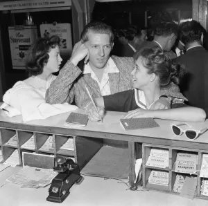 American rock and roll singer Jerry Lee Lewis signs immigration cards with his thirteen