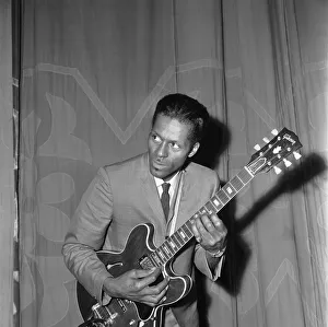 Instrument Prints: American rock and roll singer and musician Chuck Berry tunes up his guitar before going