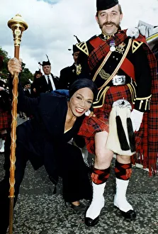 Kilt Prints: American singer and actress Eartha Kitt pulls up the kilt of a regimental Sgt Major