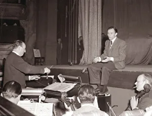 American singer and film star Frank Sinatra sitting on stage during rehearsals