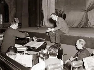 American singer and film star Frank Sinatra sitting on stage during rehearsals