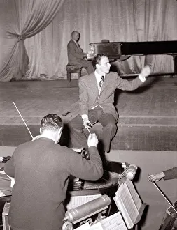 American singer and film star Frank Sinatra sitting on stage during rehearsals