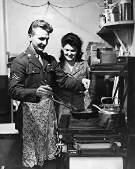 Core07 Prints: American soldier shows his English wife how he likes his steak done, circa 1944