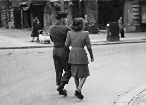 An American soldier walks arm in arm with a German civilian in Allied occupied Berlin