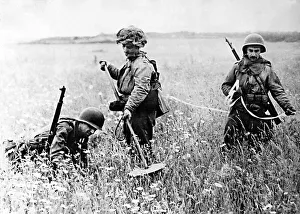 Searching Prints: American soldiers searching a field in Northern France for landmines