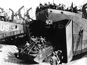 American troops drive an amphibious vehicle aboard an invasion landing craft in
