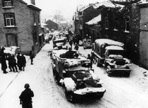 American troops pass through snow-covered street in Lierheux Belgium during WW2