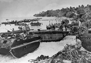 US amphibious tanks line a beach bringing in supplies to American marines who landed