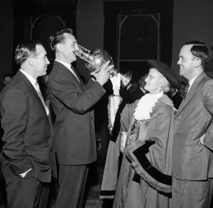 Andy Nelson Ipswich Town FC captain drinks champagne from the trophy watched by Alf