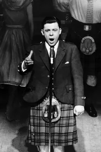 Andystewart Prints: Andy Stewart Scottish singer tanding at microphone on stage mouth open arm out