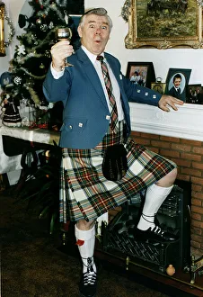 Andy Stewart singer holding goblet at home fireplace foot on fire christmass tree tartan