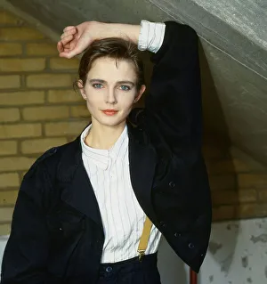 Annabel Giles model TV presenter wearing black jacket white shirt yellow braces arm above