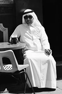 Keffiyeh Prints: Arab man sitting outside enjoying a pint of Guinness at the Stanhope public house