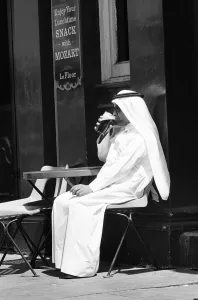 00443 Prints: Arab man sitting outside enjoying a pint of Guinness at the Stanhope public house