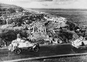 01462 Prints: Armoured cars of the South African Field Force pass ancient ruins in Cyrene during Second