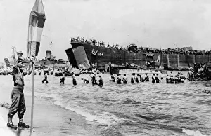 01458 Prints: A US Army beach master seen here guiding landing craft to a safe beach area to unload