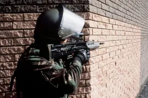 Protective Clothing Prints: Army Belfast An armed soildier talked aim round the corner of a building with his