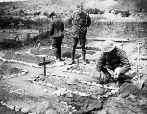 Kneeling Prints: An army chaplain tending to a British soldiers grave in 1916 in France after the Battle