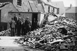 ARP personnel, Air raid warden help to search for survivors in an East Hull street after