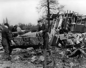 01441 Prints: ARP rescue workers removing settee from blitzed army huts used as dwellings in a field in
